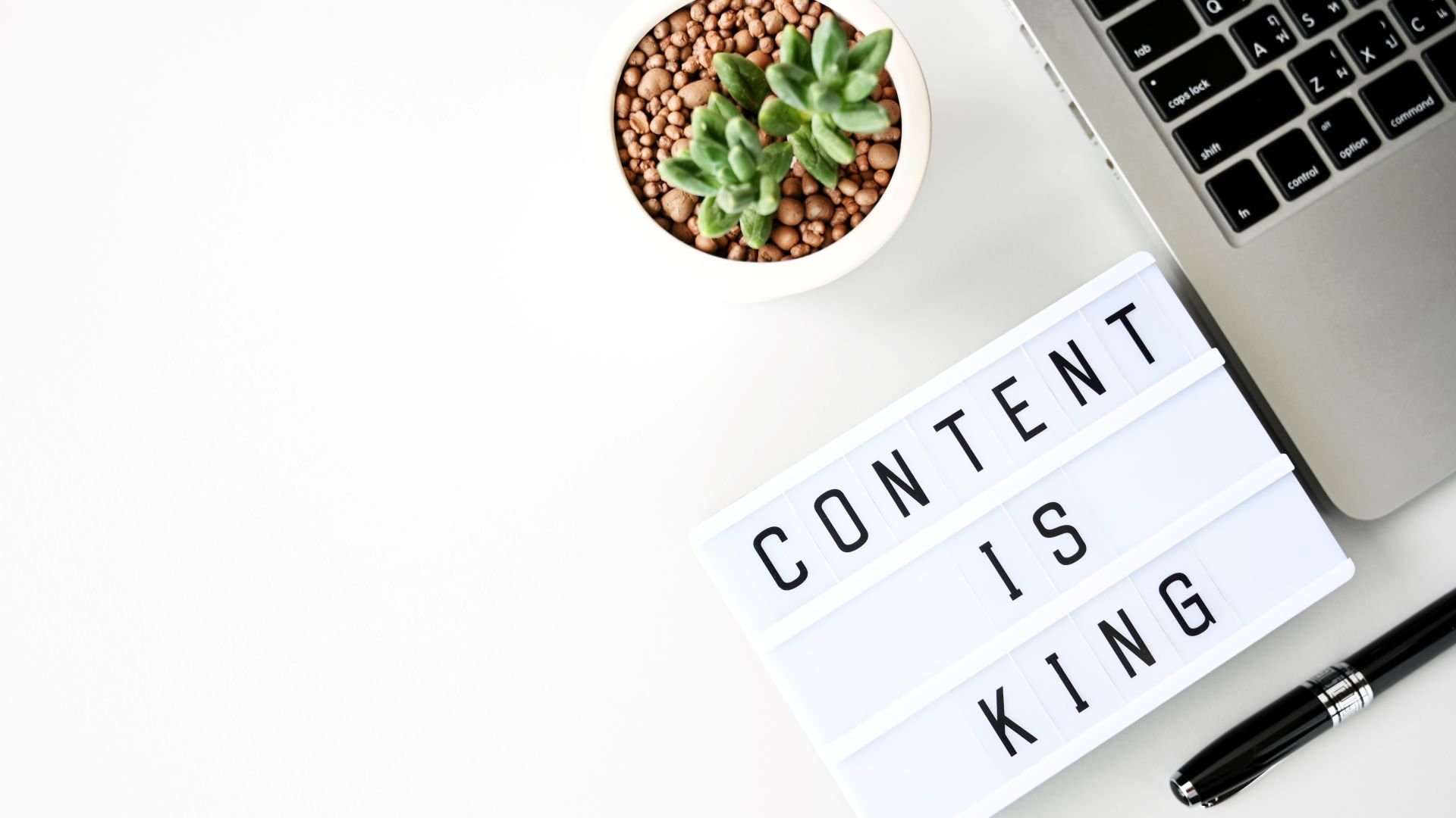 Content marketing workstation with laptop and sign saying 'content is king'