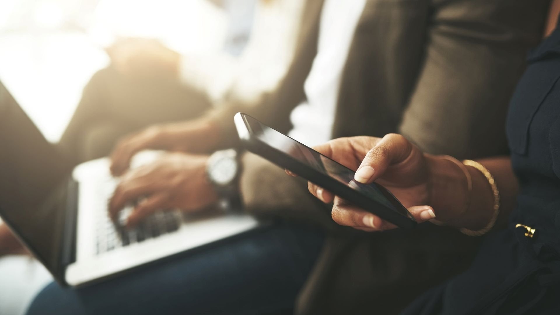 PR professionals reviewing marketing materials on a laptop and smartphone