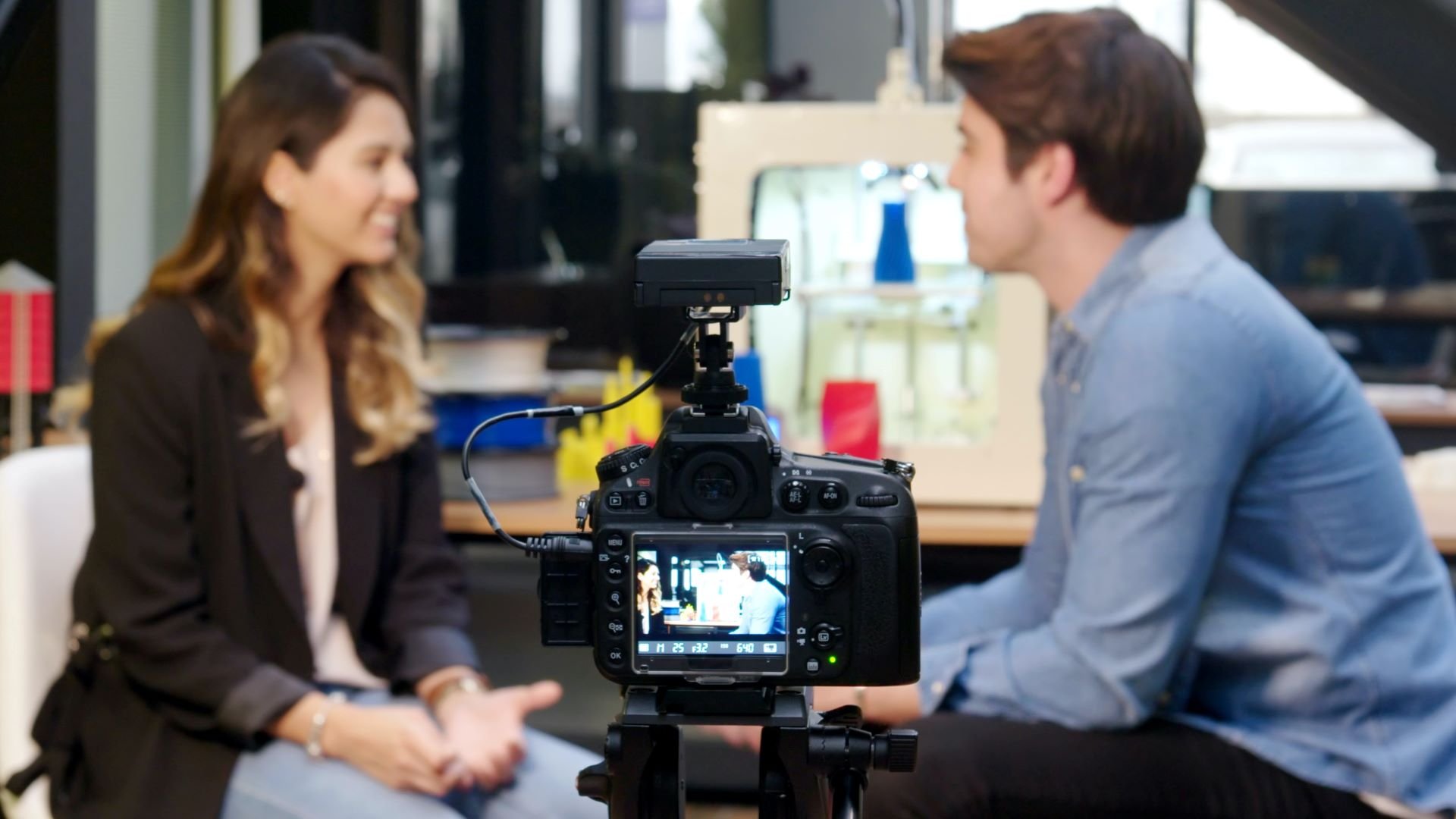 Video director preparing onscreen talent for a shoot behind a camera