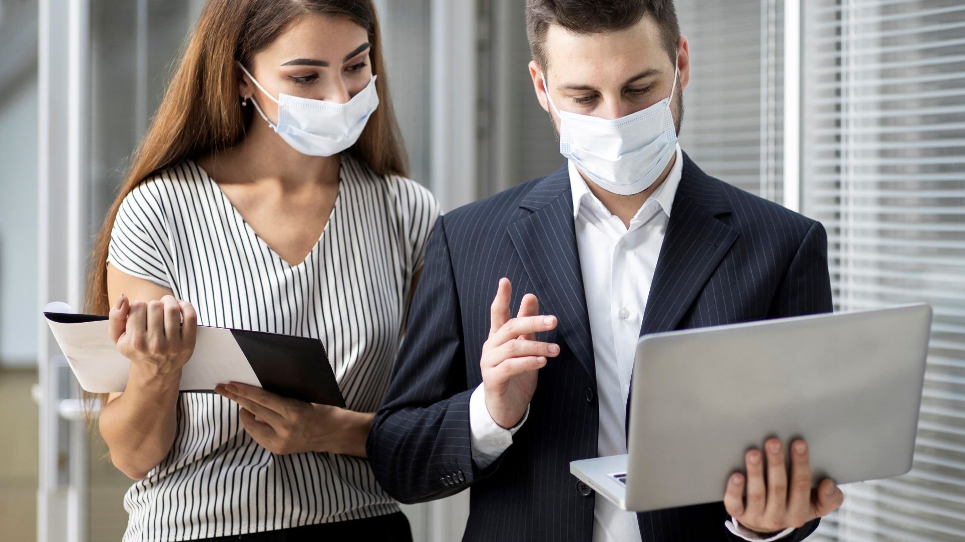 Colleagues watching a company video during COVID-19 wearing surgical masks