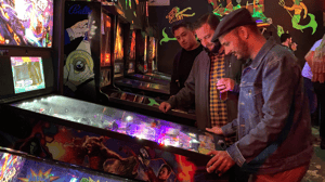 Marketing agency partners strategizing new vision over a pinball machine